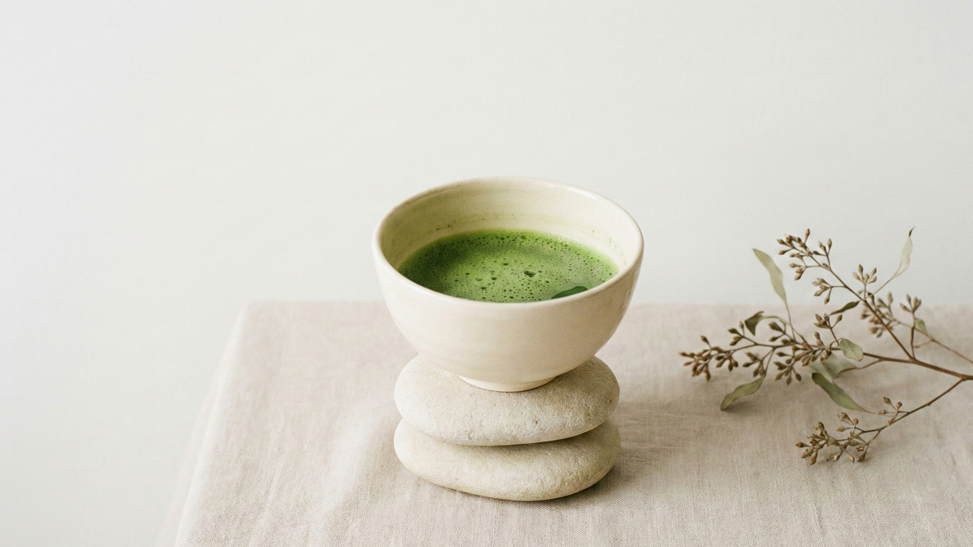 Een kom biologische ceremonial matcha rustend op twee stenen. 